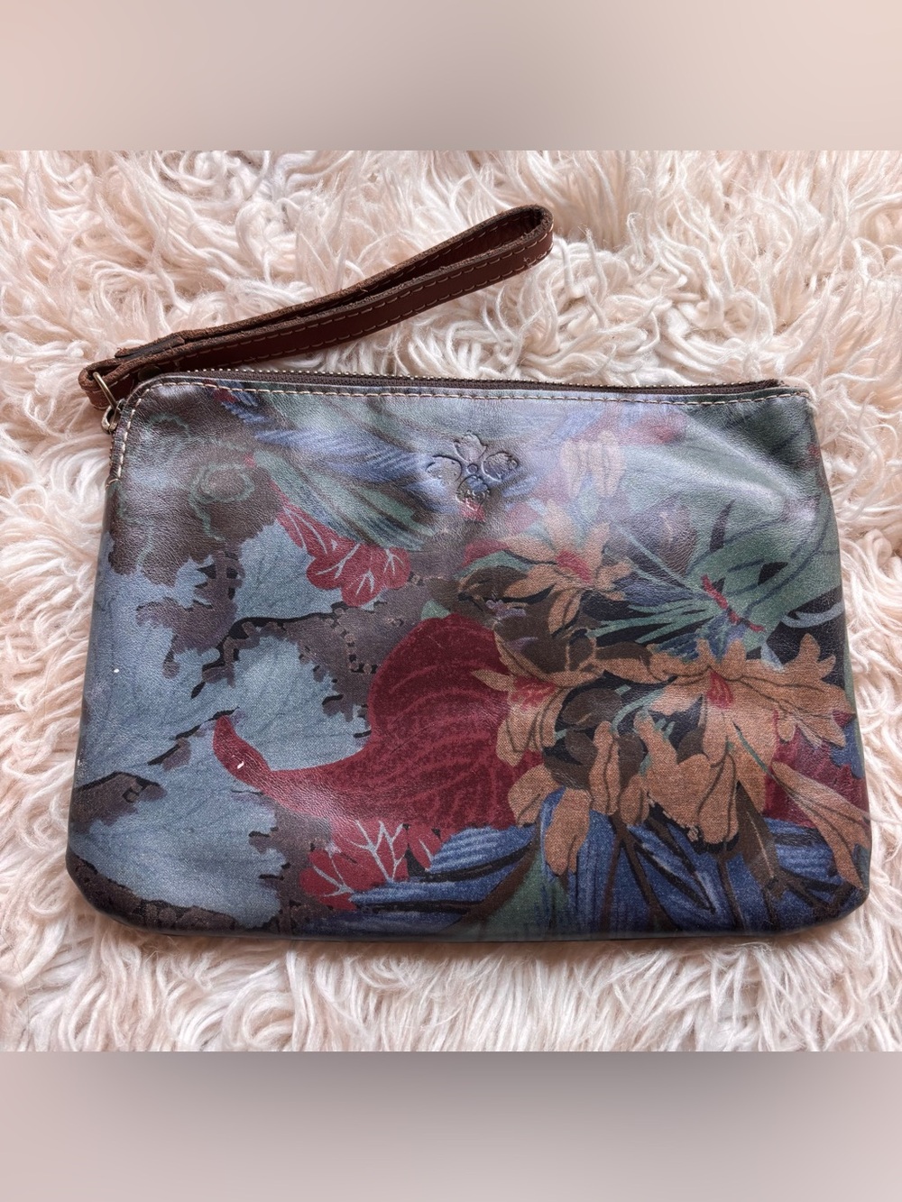Patricia Nash leather floral clutch with flowers and leaves.
